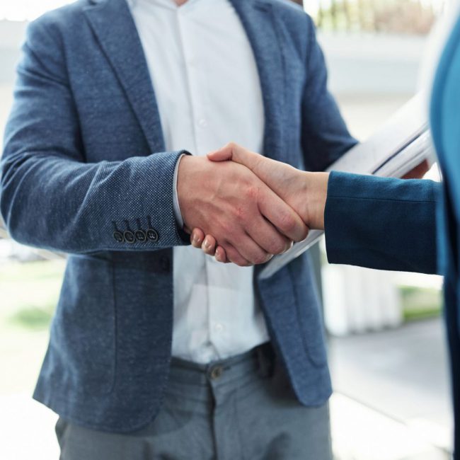 Cropped image of business people shaking hands and confirming deal