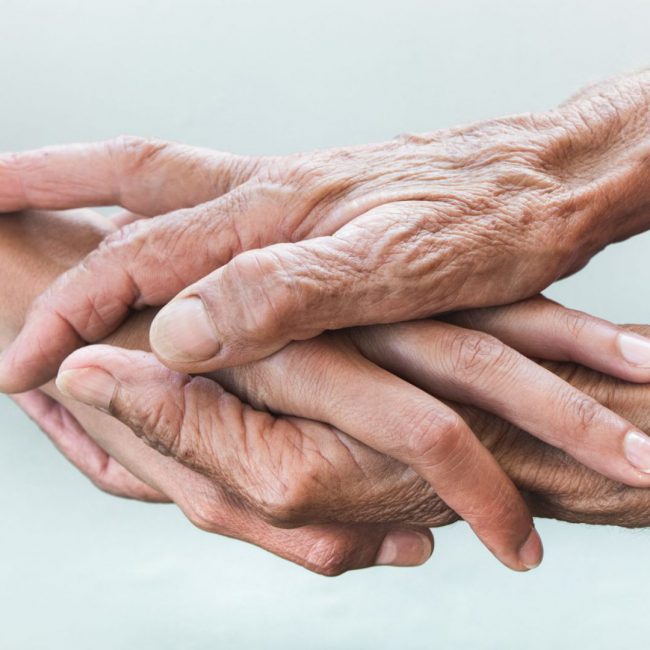 hands-of-young-adults-and-older-women-on-a-light-b-DCDSRSC